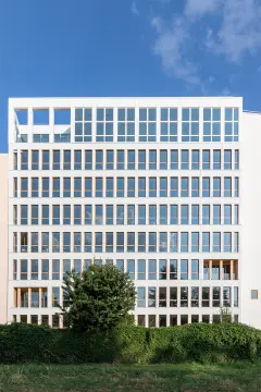 This 8-storey office building was completed in 2021, part of a major redevelopment project in the Vache-Noire district. This mixed structure of wood and concrete is finished with a white glass 5x5cm mosaic on the ventilated facade, evoking the Pate de Verre used on buildings in the area during the 1980s.