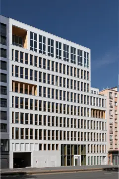 This 8-storey office building was completed in 2021, part of a major redevelopment project in the Vache-Noire district. This mixed structure of wood and concrete is finished with a white glass 5x5cm mosaic on the ventilated facade, evoking the Pate de Verre used on buildings in the area during the 1980s.