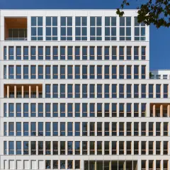 This 8-storey office building was completed in 2021, part of a major redevelopment project in the Vache-Noire district. This mixed structure of wood and concrete is finished with a white glass 5x5cm mosaic on the ventilated facade, evoking the Pate de Verre used on buildings in the area during the 1980s.