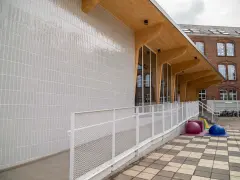 A new section has been added to Katoba primary school near Brussels, with a combination of concrete, wood, glazing and a ceramic tile facade