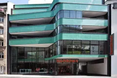 The curved glass mosaic facade of the new building references its predecessor, the Royal cinema which once stood on this site.