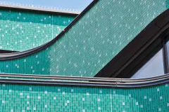 The curved glass mosaic facade of the new building references its predecessor, the Royal cinema which once stood on this site.