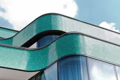 The curved glass mosaic facade of the new building references its predecessor, the Royal cinema which once stood on this site.