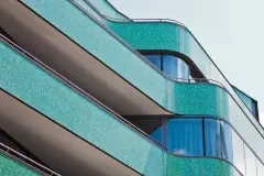 The curved glass mosaic facade of the new building references its predecessor, the Royal cinema which once stood on this site.