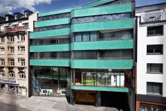 The curved glass mosaic facade of the new building references its predecessor, the Royal cinema which once stood on this site.