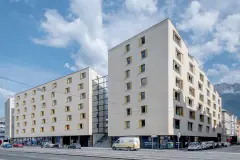 Stadt Carre residential and commercial complex features four buildings of varying heights clustered around a raised courtyard built atop the roof of the ground floor commercial space.