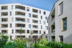 The internal courtyard of the Stadt Carre complex in Innsbruck features shared green space and children's playgrounds