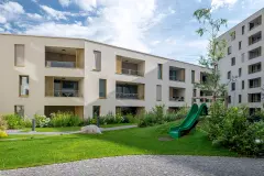 The internal courtyard of the Stadt Carre complex in Innsbruck features shared green space and children's playgrounds