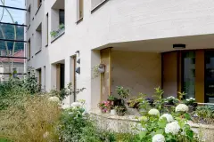 The internal courtyard of the Stadt Carre complex in Innsbruck features shared green space and children's playgrounds.