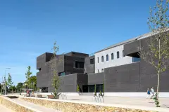 Trofa Town Hall's contrast between the old and new is evident in the materials chosen - the restored original building in fine-grained grey render with a glazed top coat; the new building volumes in a bold envelope of dark bricks.