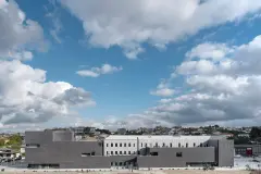 Panoramic view of Trofa Town Hall with its contrast between the old and new is evident in the materials chosen - the restored original building in fine-grained grey render with a glazed top coat; the new building volumes in a bold envelope of dark bricks.