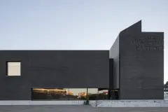 The facade of Trofa Town Hall is at times forbidding, at times inviting - with its black brick facade, the sharp-edged structure positions itself confidently in its urban setting with large openings marking the entrances.