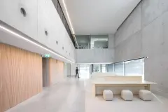 Interior of the Trofa Town Hall is bright and warm, featuring light wood and exposed concrete.