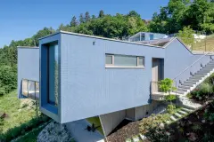 Villa Mimi at Lake Millstatt cantilevers over a hillside, finished with blue glass mosaic tiles