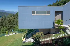 Villa Mimi at Lake Millstatt cantilevers over a hillside, finished with blue glass mosaic tiles